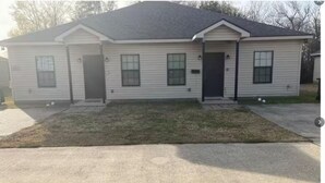 A single-story house with a front porch, a garage, and a small front yard.