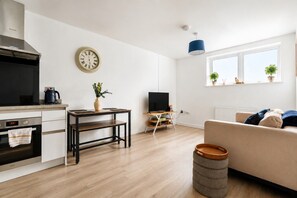 A modern living space with a kitchen, dining area, and seating area. - London Access Stay | Fast Train to Waterloo | Near Heathrow (Ashford)