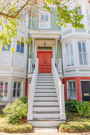 A two-story building with a red door and white steps leading to the entrance. - Serene 2-bedroom condo steps from Forsyth Park in charming Savannah (Savannah)