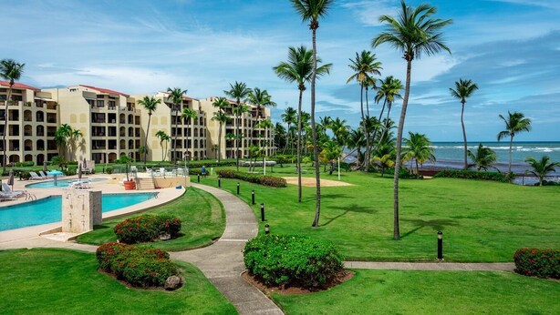 A resort with a pool, palm trees, and a view of the ocean. - Crescent Beach by Otium (Humacao)