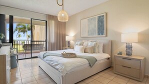A hotel room with a bed, bedside tables, a lamp, a painting, and a view of the beach. - Crescent Beach by Otium (Humacao)
