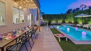 An outdoor pool area with a dining setup and lounge chairs. - Wren by Nest Villas | Private Pool, Spa & Firepit (Indio)