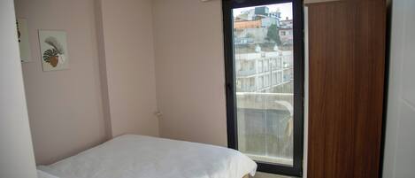 Una camera da letto con un letto, una porta e una finestra.