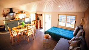 Un espace de vie compact comprenant un coin repas, une kitchenette et un coin salon confortable avec vue.