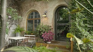 A rustic brick building with arched windows and a wooden porch. - Retiro Park Industrial House (Madrid)