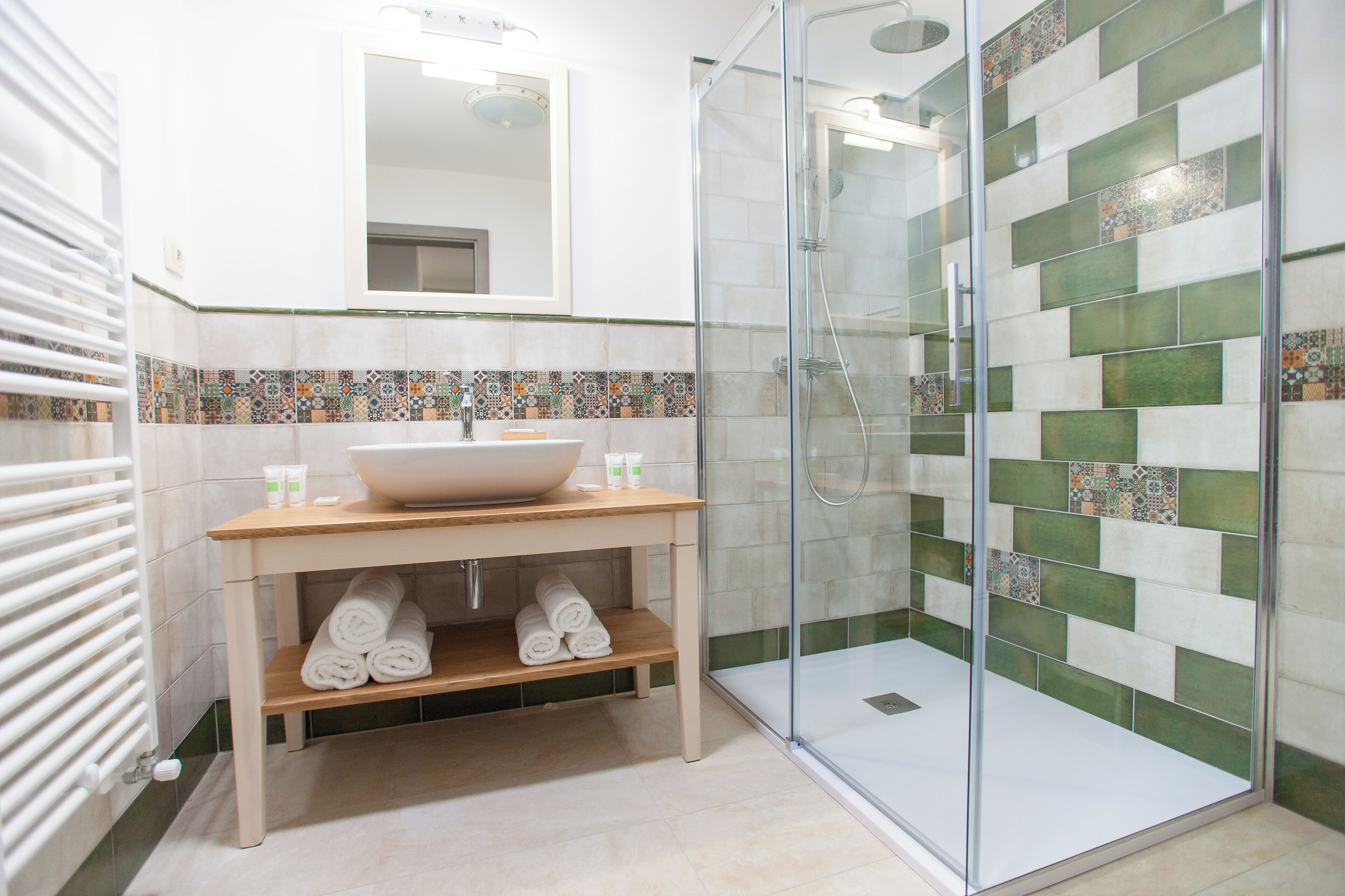 Un baño moderno con ducha de vidrio, un lavamanos grande y un salpicadero de azulejos.