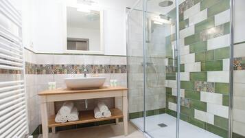 Un baño moderno con ducha de vidrio, un lavamanos grande y un salpicadero de azulejos.