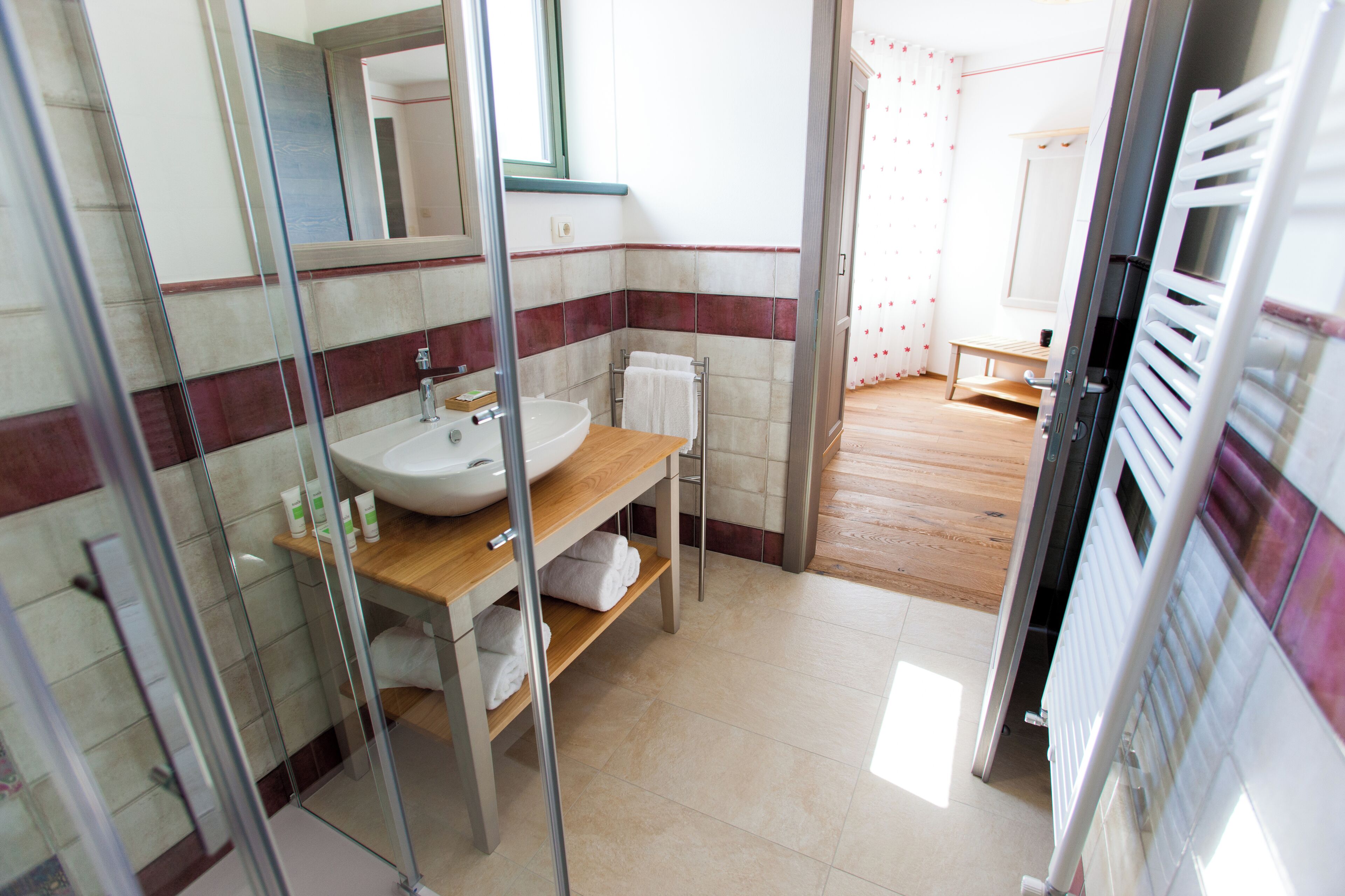 A bathroom with a sink, mirror, and towel rack.