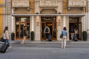 A hotel entrance with double doors, a sign reading 'Hotel Moderno,' and a number '60' on the wall.