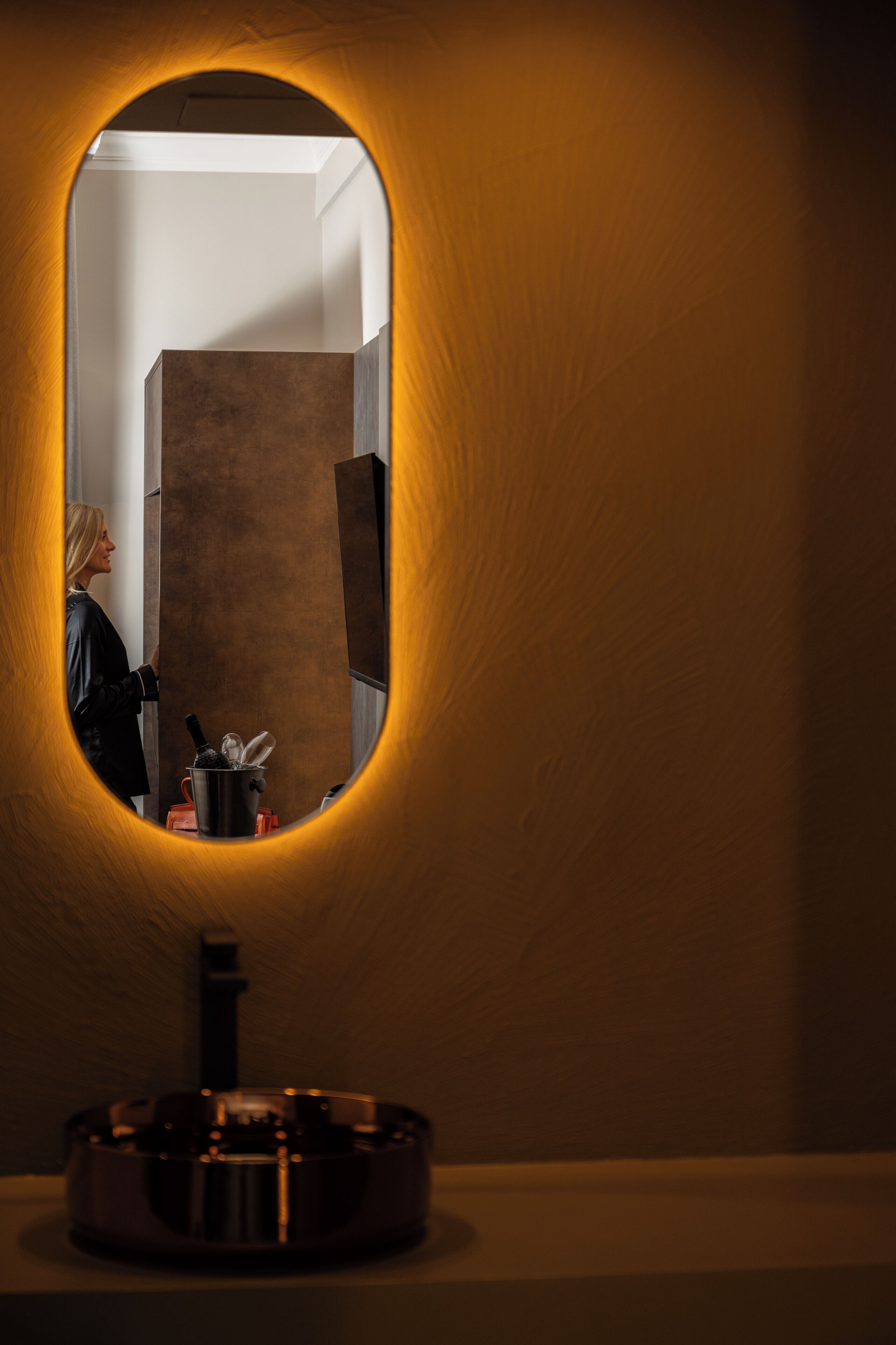 A bathroom with a mirror, a sink, and a towel rack.