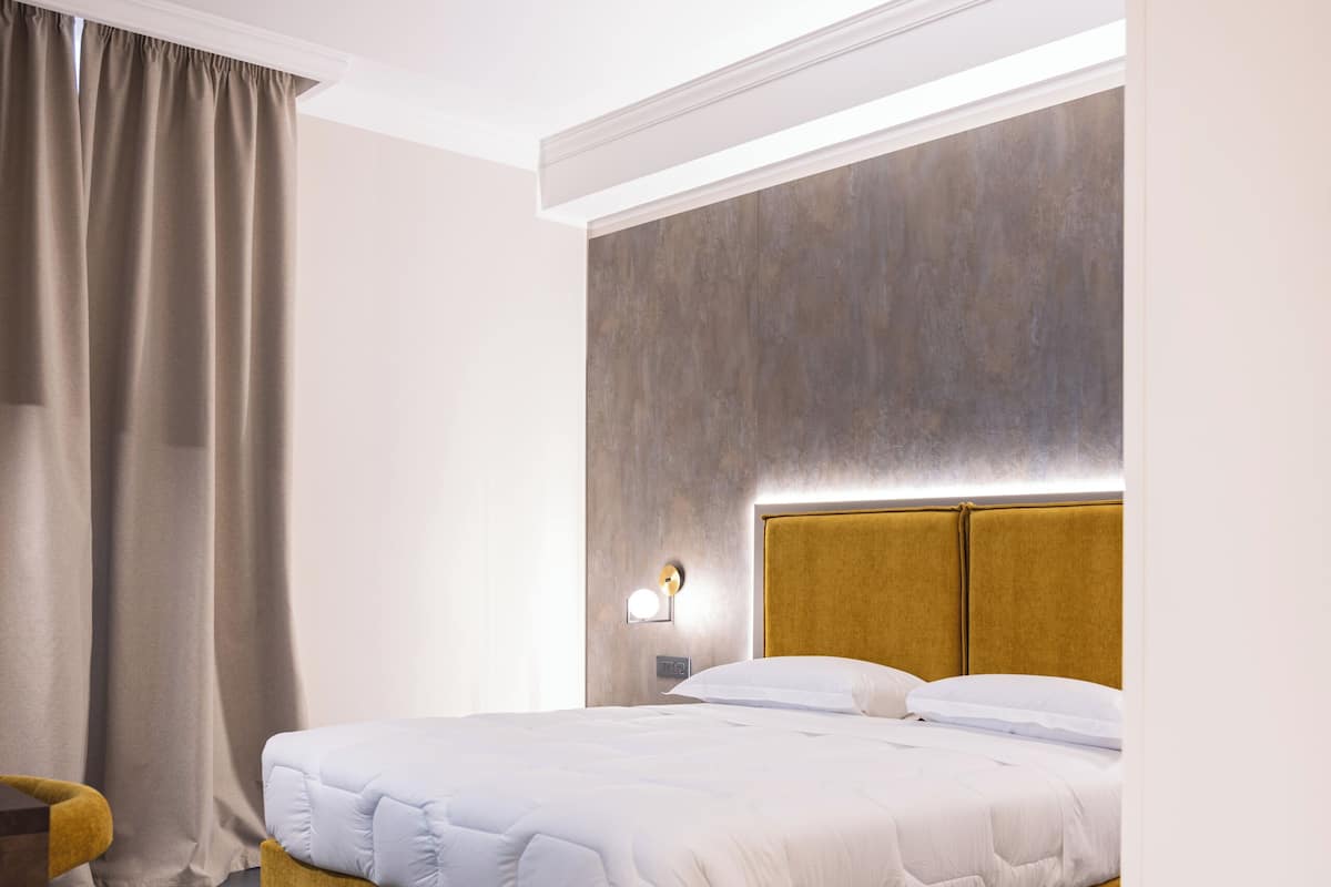 Une chambre d’hôtel moderne avec un grand lit, un bureau et une table de chevet.