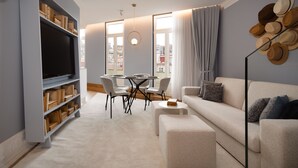 A modern living room with a sofa, a TV, a bookshelf, a dining table, and a view of the city through large windows. - Comfy 3BR Duplex in Historical Center (Oporto)