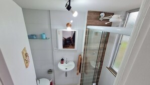 A modern bathroom with a glass shower enclosure, a sink, and a toilet. - Studio 325 Teresópolis - Best Location.  WATERFALLS AND GASTRONOMY (Teresópolis)