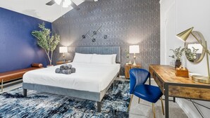 Une chambre d’hôtel moderne équipée d’un grand lit, d’un bureau et d’un ventilateur de plafond.