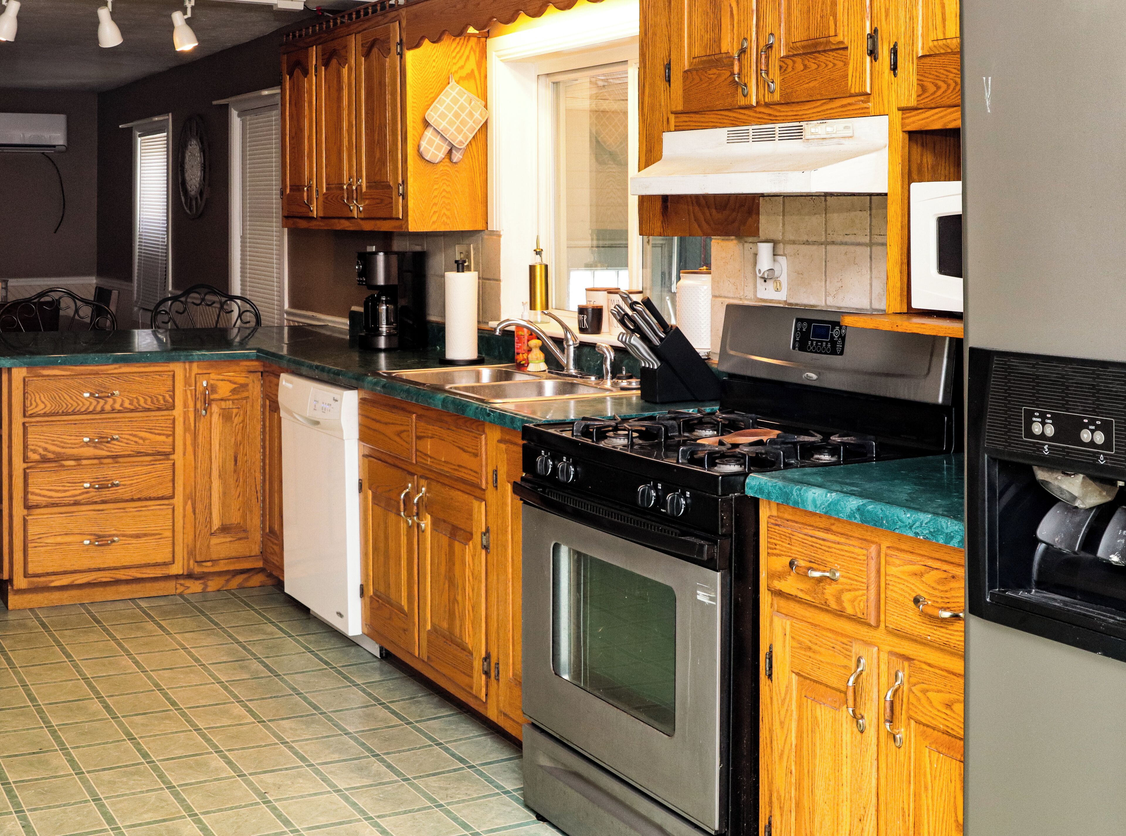 A kitchen with wooden cabinets, a stainless steel stove, and a dishwasher.