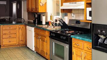 A kitchen with wooden cabinets, a stainless steel stove, and a dishwasher.