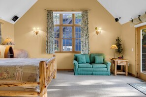 A room with a bed, a green sofa, a window with curtains, and wall-mounted lamps. - Alden East Torch Estate (Alden)