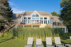 A large house with a covered deck, a staircase, and a pool area. - Alden East Torch Estate (Alden)