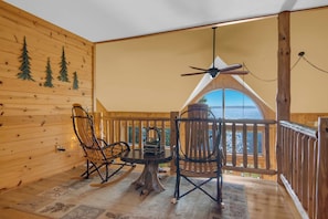 A wooden cabin interior with a dining table, chairs, and a ceiling fan. - Alden East Torch Estate (Alden)