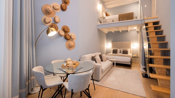 A modern living room with a glass dining table, a sofa, and a staircase. - Sweet Studio for 4 in Historical Center (Oporto)