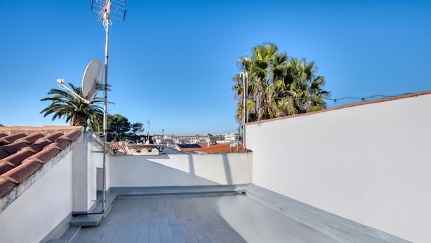 A rooftop terrace with a clear view of the cityscape, satellite dishes, and palm trees. - MIRAVETTE: Cozy house in L’Escala near the harbor (L'Escala)