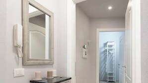 A hallway with a white vanity, a mirror, and a telephone. - Double apartment with 2 independent entrances in the historic center of Florence (Firenze)