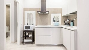 A modern kitchen with white cabinetry, a microwave, a toaster, and a kettle on the counter. - Double apartment with 2 independent entrances in the historic center of Florence (Firenze)