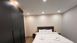 A bedroom with a bed, a wardrobe, and a nightstand. - Boutique Hotel 108 (Bishkek)