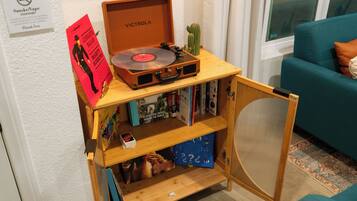 A wooden music player with a vinyl record, surrounded by books and a cactus.