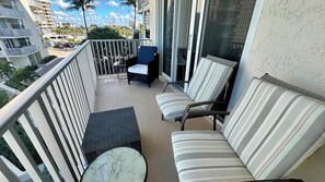 Ein Balkon mit einer Couch, einem Sessel und einem kleinen Tisch.