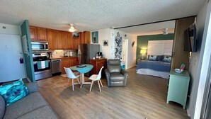 A compact living space with a kitchenette, a dining area, and a bedroom. - Estero Beach & Tennis 205B - Beach View (Fort Myers Beach)