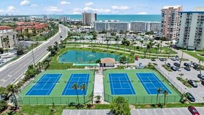 A residential area with two tennis courts, a swimming pool, and a parking lot. - Estero Beach & Tennis 205B - Beach View (Fort Myers Beach)