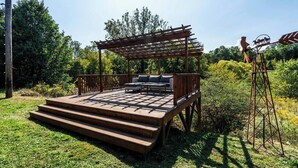 A wooden deck with a pergola and outdoor seating area. - Spacious Barn Apt w/ King Bed (Asheville)