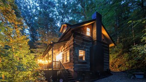 A log cabin with a porch, a staircase, and a gravel driveway. - Romantic Asheville Log Cabin w/ Hot Tub & Gym (Asheville)