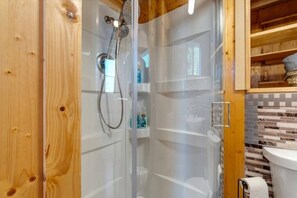 Chuveiro, secador de cabelo, toalhas de banho, shampoo