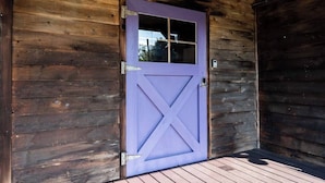 Ein Holthaus mit einer violetten Tür und einem kleinen Fenster.