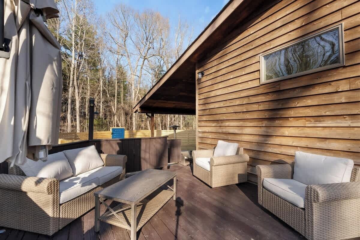 A wooden deck with wicker furniture and a bar area.