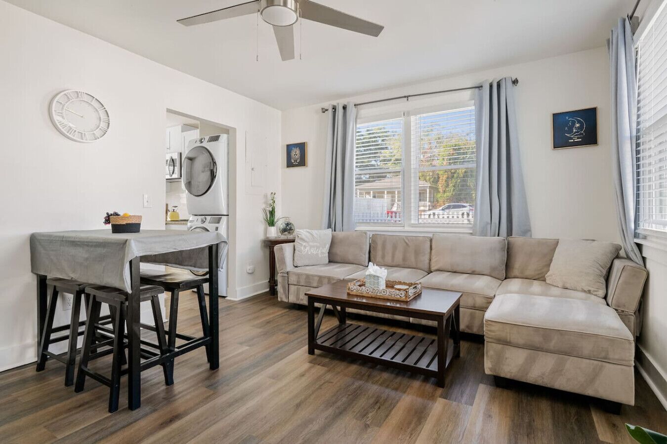 Een moderne woonkamer met een bank, salontafel en een eethoek met een tafel en stoelen.