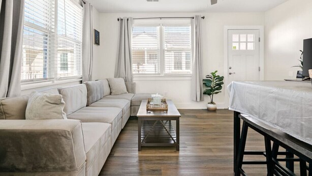 Ett modernt vardagsrum med en soffa, ett soffbord och en matplats.