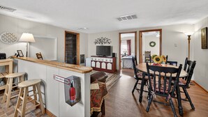 A modern kitchen with wooden countertops, a built-in stove, and a dining area with a wooden table and chairs.
