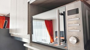 A modern microwave with a digital display, control buttons, and a stainless steel finish. - Modern, impeccable, close to terminals in the city of Temuco. (Temuco)