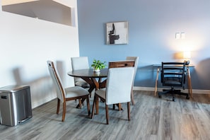 A dining area with a round table, four chairs, a small potted plant, and a wall-mounted artwork. - Landing Apartments Downtown Salt Lake City Near Trolley Square (Salt Lake City)