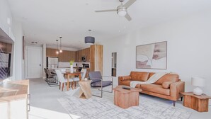 Ein modernes Wohnzimmer mit Sofa, Couchtisch und Essbereich.