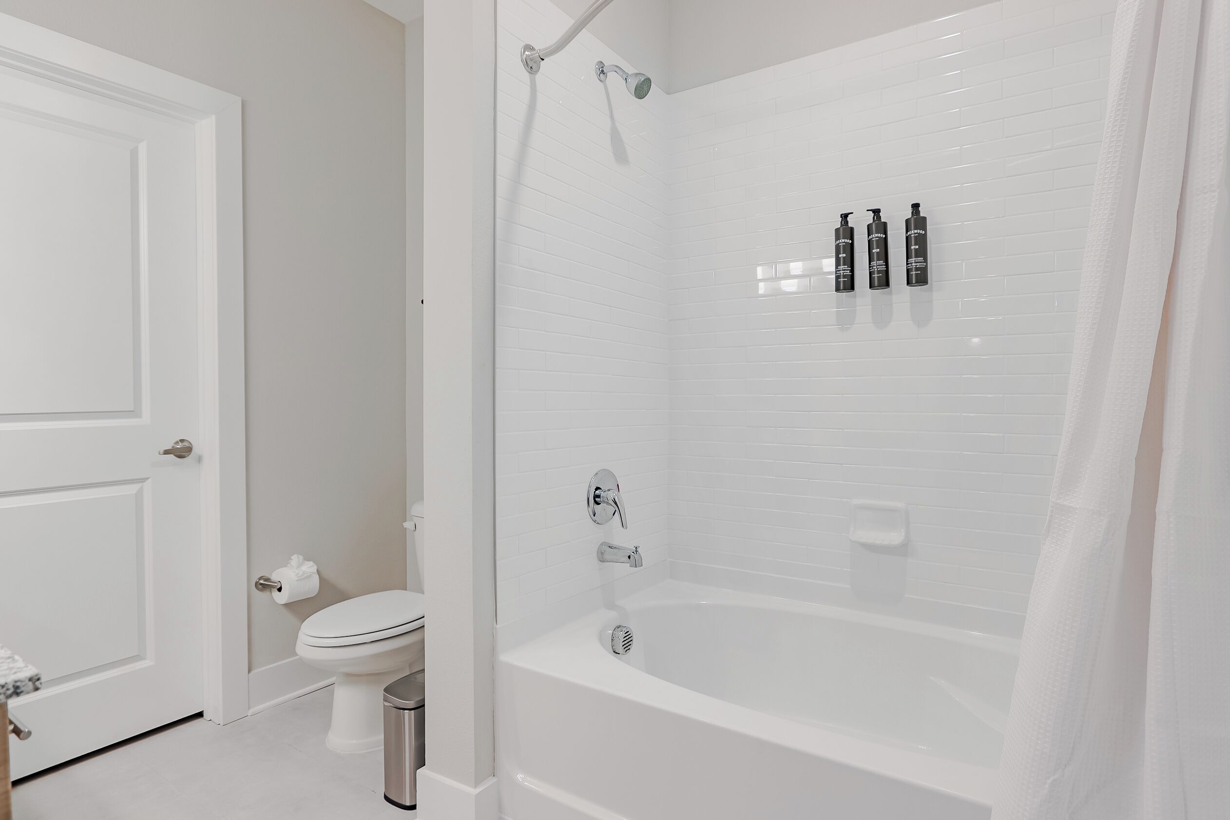 Un baño con una bañera blanca, un inodoro y una zona de ducha.