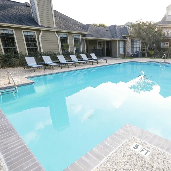 A swimming pool with lounge chairs and a 5 FT depth marker. - Landing Amazing 1bd, Clubhouse, Pool (San Antonio)