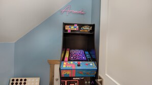 A room with a neon sign reading "Arcade" and a collection of arcade machines. - Little Haven Chalet (Pigeon Forge)