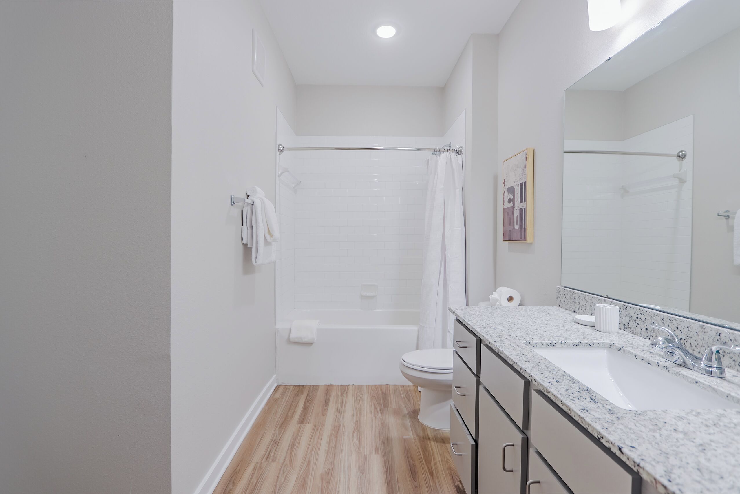 A modern bathroom with a shower, toilet, and sink.