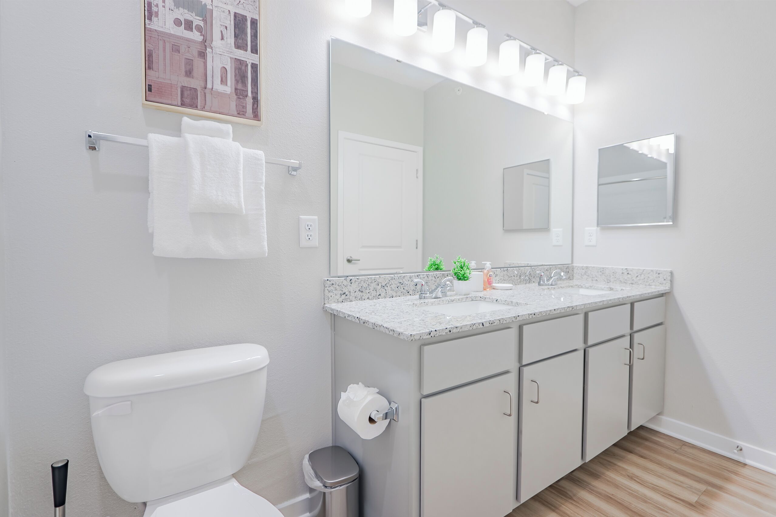 A modern bathroom with a toilet, sink, and vanity.