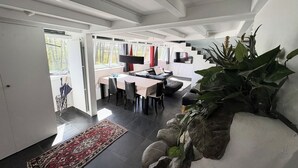 Ein modernes Interieur mit Essbereich, einer Couch und einer Treppe.