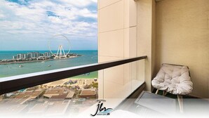 A balcony with a view of a beach and a Ferris wheel. - Premium Iconic Beachside JBR Stay (Dubai)